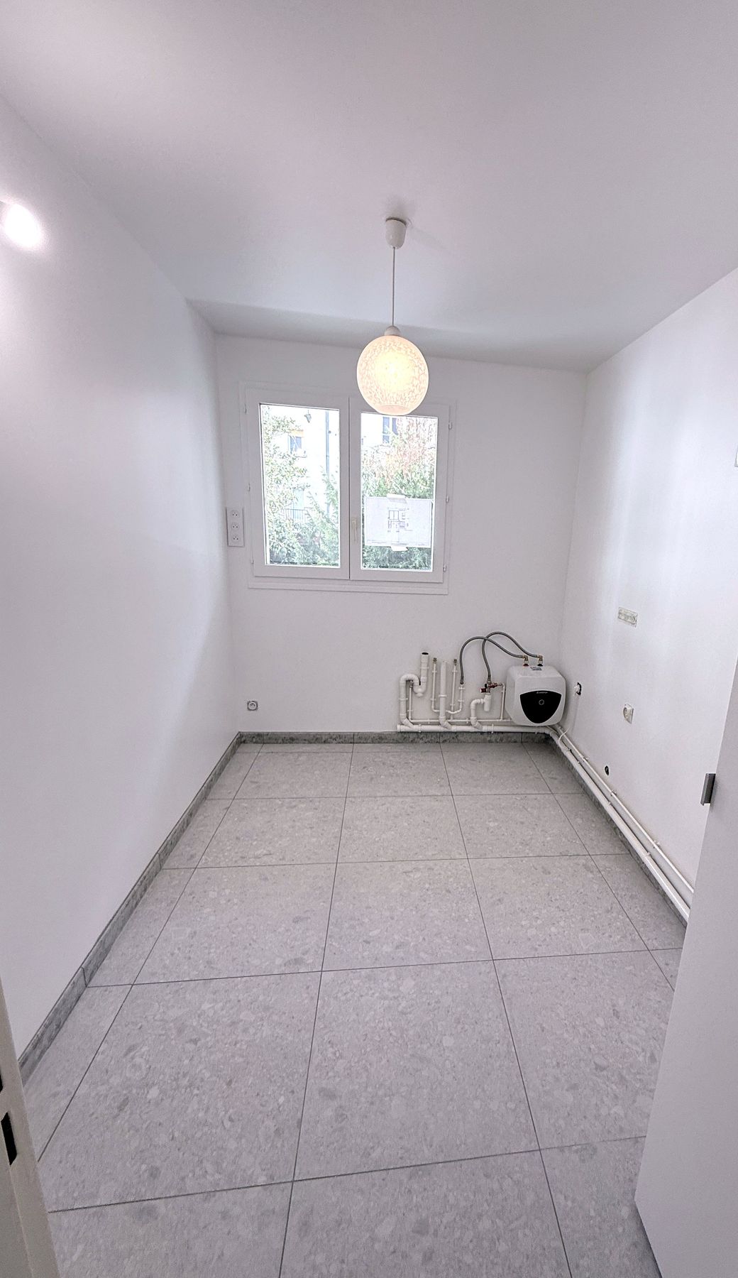Cuisine rénovée, carrelage 60×60, ballon Ariston, murs blancs