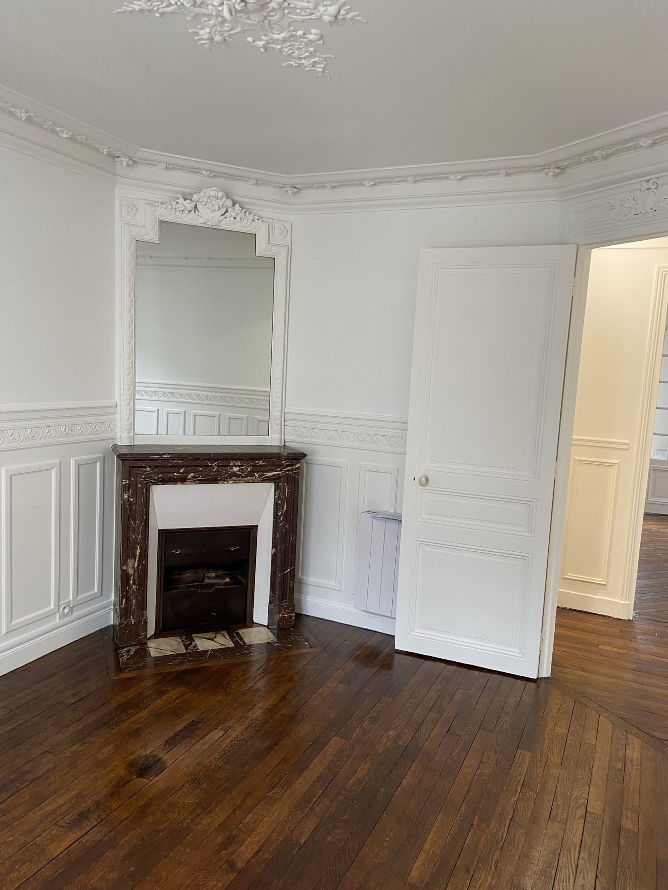 Salon avec cheminée et fenêtre parisienne